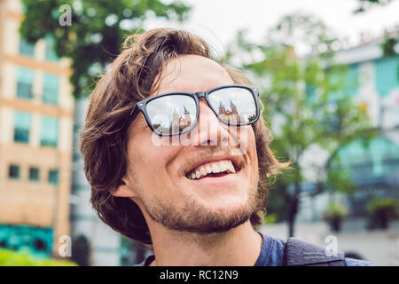 Ein Mann schaut auf Notre Dame de Saigon Kathedrale, gebaut 1883 in Ho Chi Minh City, Vietnam. Reflexion in der Brille. Stockfoto
