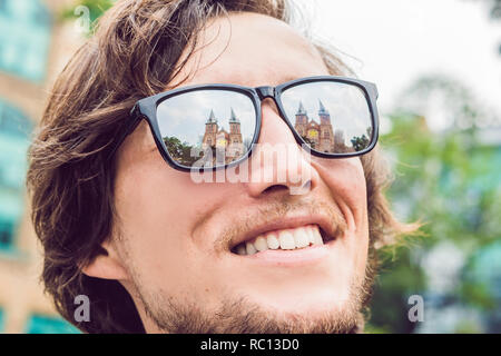 Ein Mann schaut auf Notre Dame de Saigon Kathedrale, gebaut 1883 in Ho Chi Minh City, Vietnam. Reflexion in der Brille Stockfoto