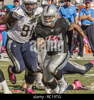 Oakland, Kalifornien, USA. 12. Okt. 2014. Oakland Raiders zurück laufen Maurice Jones - zeichnete (21) abläuft, San Diego Chargers defensive Ende Kendall Reyes (91) am Sonntag, 12. Oktober 2014 in Oakland, Kalifornien. Die Ladegeräte besiegt die Räuber 31-28. Credit: Al Golub/ZUMA Draht/Alamy leben Nachrichten Stockfoto