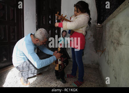 Januar 13, 2019 - Gaza, Gazastreifen, Palästinensische Autonomiegebiete - eine palästinensische Künstlerin, Mahdi Karira, 39, macht eine Marionette an seinem Haus, in Gaza Stadt, am 13. Januar 2019. Eine Marionette ist eine Marionette von oben über Kabel oder Streicher je nach regionalen Variationen gesteuert. Ein Marionettentheater Puppenspieler ist ein marionettist genannt. Marionetten sind mit der Puppenspielerin versteckt vor einem Publikum gezeigt, indem Sie eine vertikale oder horizontale Control Bar in verschiedenen Formen von Theater oder Unterhaltungsmöglichkeiten oder Betrieben. Sie haben auch in Film und Fernsehen eingesetzt. Die Befestigung der Saiten variiert ein Stockfoto