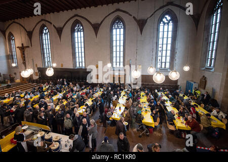 Stuttgart, Deutschland. 13 Jan, 2019. Besucher sitzen an Tischen während des ersten Tages des Vesper Kirche. Zum 25. Mal, die älteste Vesperkirche in Deutschland bietet bedürftigen Menschen mit warmen Mahlzeiten und mehr für sieben Wochen. Credit: Sebastian Gollnow/dpa/Alamy leben Nachrichten Stockfoto