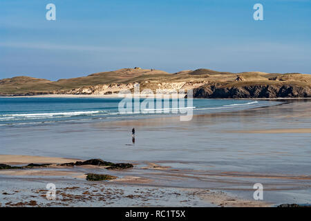 Einsame person Waten durch Waschen im Balnakeil Bay in der Nähe von Durness in Sutherland Highland Schottland mit Faraid Head hinter Stockfoto