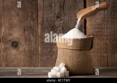 Zucker in den Sack fallen auf Holz- Hintergrund Stockfoto