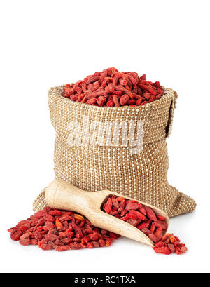 Getrocknete Goji Beeren in Sack und hölzerne Schaufel auf weißem Hintergrund Stockfoto
