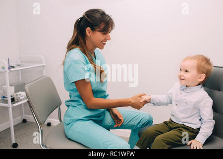 Handshake mit kleinen Patienten, bei medizinischen Büro. Beratung und Aufnahme der Kinder Audiologen Stockfoto