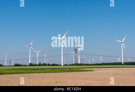 Freileitungen und moderne Windkraftanlagen in den Feldern in Deutschland Stockfoto