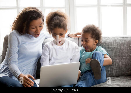 Afrikanische Mutter und Kinder am Laptop Gefühl überrascht Aufgeregt Stockfoto