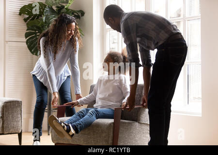 Gerne afrikanische amerikanische Eltern mit Kind Tochter auf Sessel Stockfoto