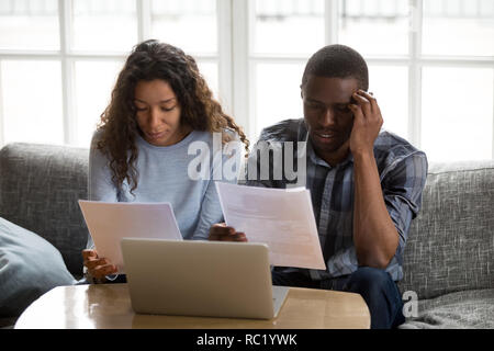 Ernsthafte betroffenen afrikanischen amerikanischen Paar hält Rechnungen lesen Stockfoto