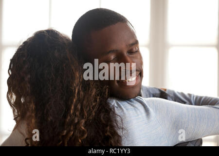 Gerne zärtlich schwarzer Mann umarmt Frau aufrichtig genießen. Stockfoto