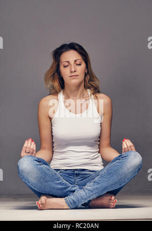 Junge Frau ist im Yoga in einem Studio eingerückt Stockfoto