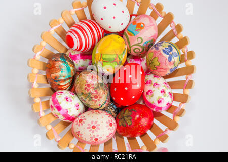 Bunt verziert und Ostereier in Holz- korb auf weißem Hintergrund gemalt. Ostern Konzept. Stockfoto