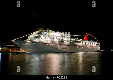 Nassau/Bahamas - Februar 7.2007: Blick auf die beleuchtete weiße Carnival Cruise Schiff bei Nacht von der Seebrücke angedockt. Stockfoto