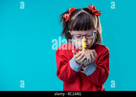 Hübsches kleines Mädchen mit roten Hoodie und Holding muffin Stockfoto