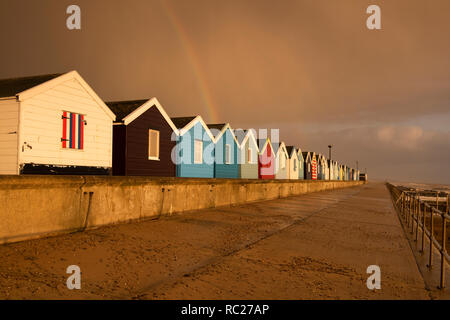 Regenbogen über Holzhütten am Southwold in Suffolk, England Großbritannien Stockfoto