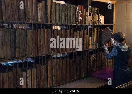 Dr. Rosemary Firman während der jährliche Reinigung der Hereford verkettete Bibliothek bei Hereford Cathedral, Herefordshire. Die Verkettung der Bücher war die am weitesten verbreitete und effektive Sicherheit System in den europäischen Bibliotheken vom Mittelalter bis in das 18. Jahrhundert, und Hereford Cathedral aus dem 17. Jahrhundert verkettete Bibliothek ist die größte mit all seinen Ketten, Stangen, um zu überleben und Schlösser intakt. Stockfoto