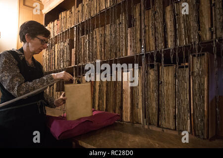 Dr. Rosemary Firman während der jährliche Reinigung der Hereford verkettete Bibliothek bei Hereford Cathedral, Herefordshire. Die Verkettung der Bücher war die am weitesten verbreitete und effektive Sicherheit System in den europäischen Bibliotheken vom Mittelalter bis in das 18. Jahrhundert, und Hereford Cathedral aus dem 17. Jahrhundert verkettete Bibliothek ist die größte mit all seinen Ketten, Stangen, um zu überleben und Schlösser intakt. Stockfoto