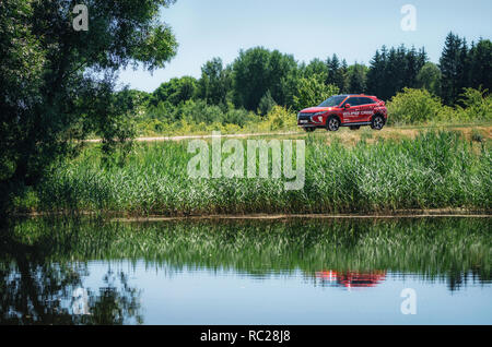 Kosava, Belarus - Juni 7, 2017: Neue 2018 Mitsubishi Eclipse Kreuz im grünen Wald. Fluss im Vordergrund. Stockfoto