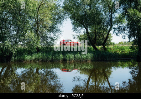 Kosava, Belarus - Juni 7, 2017: Neue 2018 Mitsubishi Eclipse Kreuz mit Reflexion im Fluss im grünen Wald Stockfoto