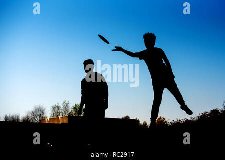 Silhouette der Junge werfen Frisbee spielen disk Golf Stockfoto