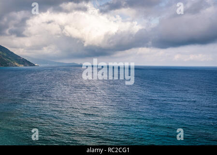 Marine mit offenen ruhige See und bewölkter Himmel mit cumulus Wolken spiegelt sich auf der Oberfläche von der Küste von Gioiosa Marea in der Nähe von Capo d'Orlando gesehen Stockfoto