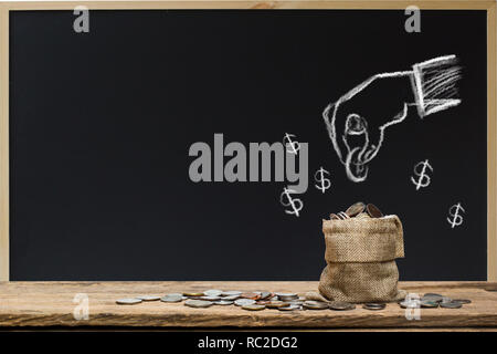 Spart Geld. Geldanlage Konzept. Hand Zeichnung auf schiefertafel Hand Münze über Geld beutel. Stockfoto
