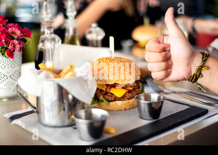 Cheeseburger mit Pommes Frites im Restaurant serviert. Stockfoto