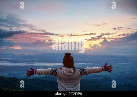 Frau Tourist in einem Pullover Kleid ständigen ausgestreckten Armen, glücklich, während Sie die schöne Natur Landschaft der Wald und Berg während der Stockfoto