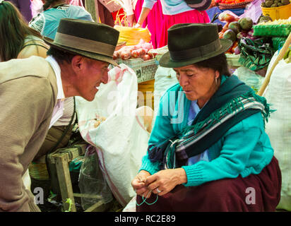 Cuenca, Ecuador/Dec 30, 2012: Mann spricht mit widerstrebenden Frau im Markt Stockfoto