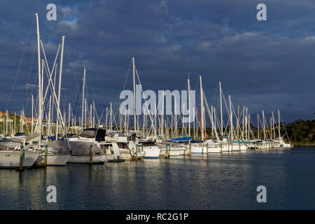 Stürmischen Himmel mit späten Nachmittag Sonne über Gulf Harbour Marina, Auckland, Neuseeland Stockfoto