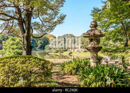 Steinlaterne mit Daisensui Teich im Hintergrund, Rikugien Gärten, Tokyo, Japan Stockfoto