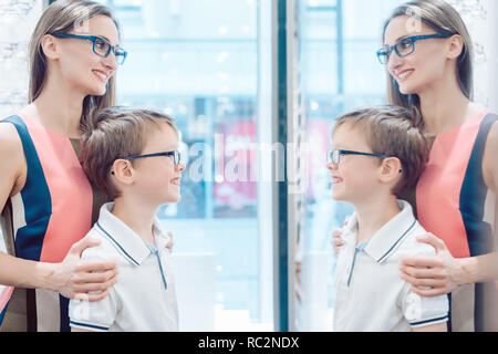 Mutter und Sohn testen neue Brille im Spiegel Stockfoto