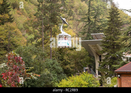 BORJOMI, Georgien - 26. SEPTEMBER 2018: Seilbahn in Resort Park von Borjomi. Menschen Aufstieg auf den Gipfel des Berges in der Gondel Stockfoto