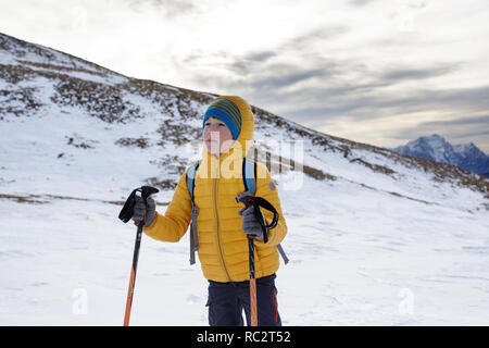 Nahaufnahme eines jungen Wandern auf Gras bedeckte Berge im Winter mit tollem Blick über die Julischen Alpen, Slowenien, Pticji vrh Stockfoto