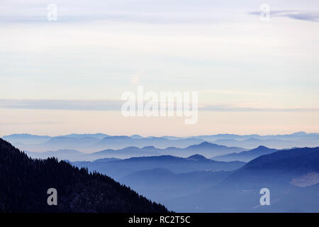 Junge Wandern auf Gras bedeckte Berge im Winter mit tollem Blick über die Julischen Alpen, Slowenien, Pticji vrh Stockfoto