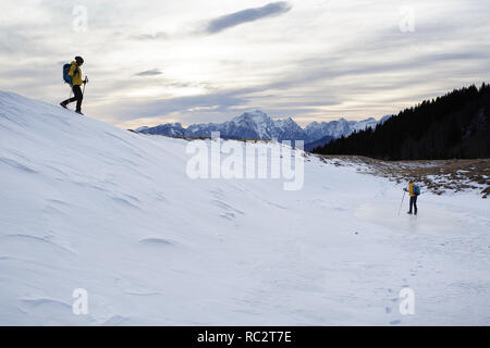 Junge Wandern auf Gras bedeckte Berge im Winter mit tollem Blick über die Julischen Alpen, Slowenien, Pticji vrh Stockfoto