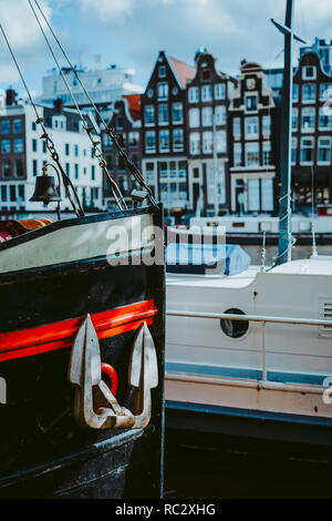 Nahaufnahme der Bug des Schiffs und Anker. Amsterdam Niederlande tanzen Häuser über den Fluss Amstel im Hintergrund Stockfoto