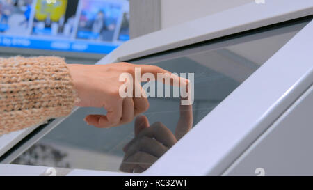 Nahaufnahme von Frau hand mit interaktiven Touchscreen Display an den städtischen Ausstellung - Scrollen und berührend. Bildung und Technologie Konzept Stockfoto