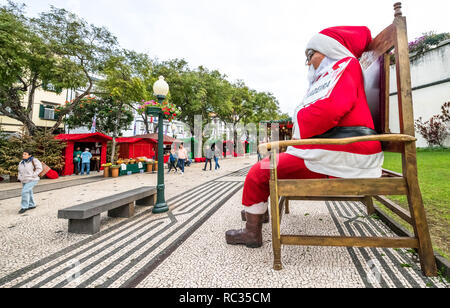 Große Abbildung von Santa Claus oder der Weihnachtsmann saß auf einem Stuhl als Touristenattraktion in einem Markt im Freien, Funchal, Madeira. Stockfoto