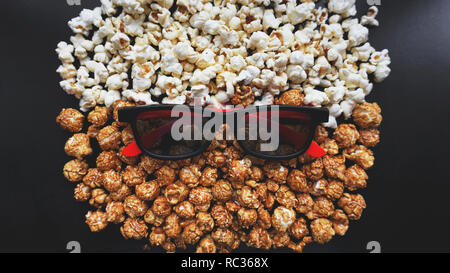 Abstraktes Bild von Viewer, 3D-Brillen und Popcorn auf schwarzem Hintergrund Stockfoto