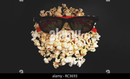 Abstraktes Bild von Viewer, 3D-Brillen und Popcorn auf schwarzem Hintergrund Stockfoto