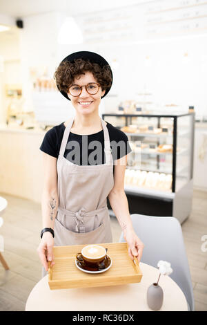Glückliche Frau in Schürze im Coffee shop arbeiten Stockfoto