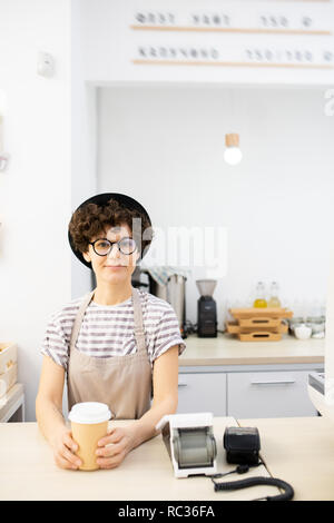 Schöne Dame mit Hut stehend an Zähler in Coffee House Stockfoto