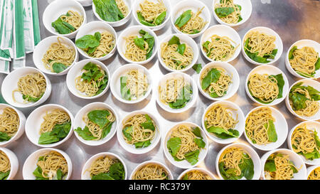 Vorbereitung der Thailändische oder Chinesische asiatische Nudelsuppe mit Baby Spinat - asiatische Nudeln, Schalen mit Nudeln mit gepackten Chinesischen sticks - Ansicht von oben Stockfoto