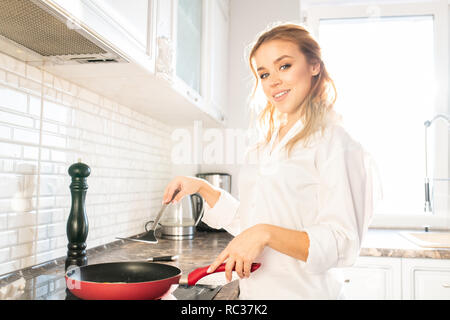 Junge Frau Kochen Frühstück Stockfoto