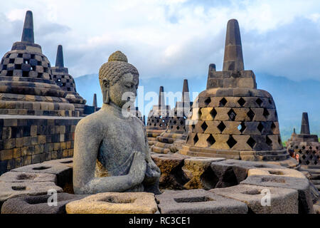 Eine Statue des Buddha, unter 72 mini Stupas an den antiken Tempel Borobudur, in Yogyakarta, Java, Indonesien eingebettet Stockfoto