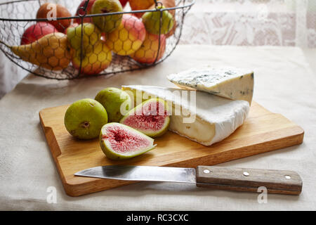 Camembert und Blauschimmelkäse mit Feigen auf einem Schneidebrett Stockfoto