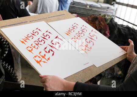 Seattle, Washington, USA. 12. Januar 2019. Ein freiwilliger bewegt sich fertige Drucke auf trockenständer am Pratt Fine Arts Center Print Studio. Die Anhänger wurden eingeladen, positive Widerstand Plakat ausdrucken bei einer Party für die kommende Womxn im März auf Seattle 2019 erstellen. Die Rallye und März, durch Seattle Womxn marschiert vorwärts organisiert, wird am 19. Januar 2019 statt, Anpfiff ein Wochenende von Gebäude macht durch Gemeinschaft, Protest, und Aktivismus. Credit: Paul Christian Gordon/Alamy leben Nachrichten Stockfoto