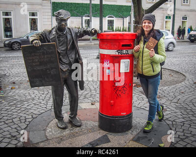 PORTO, PORTUGAL - Dezember 16, 2016: Junge touristische Dame mit dem Porto Postkarte neben roter Pfosten, lebensgroße Bronzestatue von Ardina (Portug Stockfoto