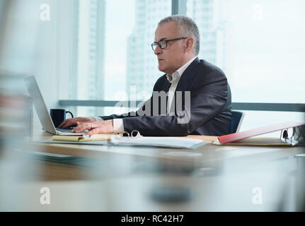 Business Mann mit Eyelasses bei der Arbeit im Büro mit Pc Stockfoto